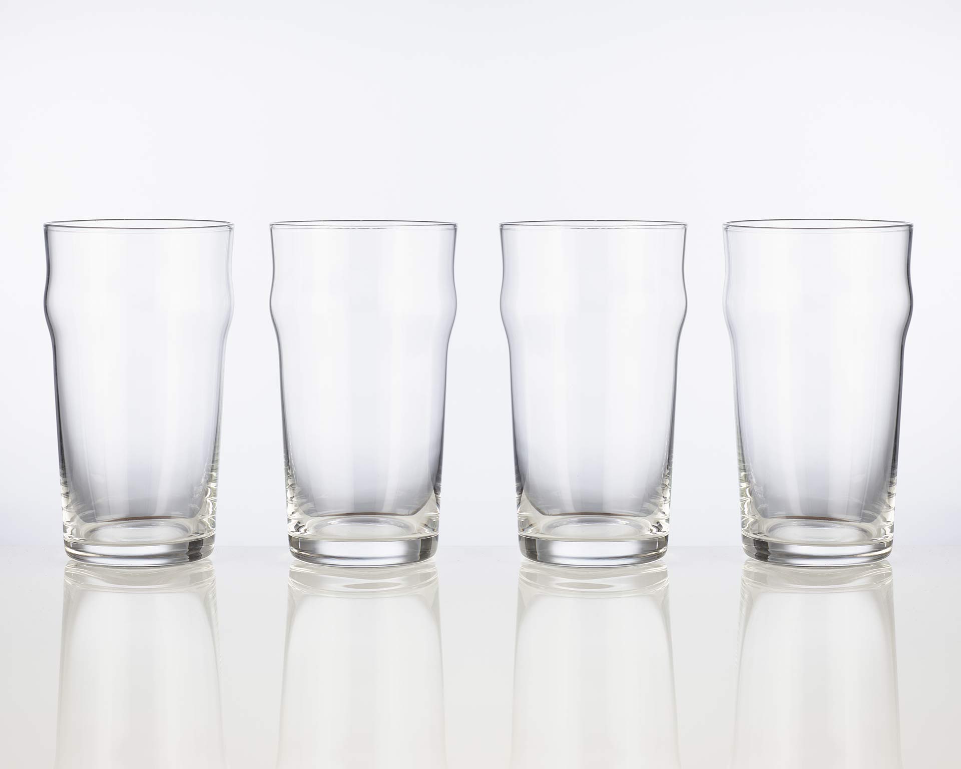 Set of 4 empty nonic 19oz imperial pint glasses in a row.